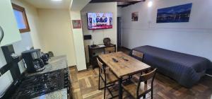 een kamer met een tafel en een bed en een keuken bij LA CASA DE FRIDA in Ushuaia +17 foto's
