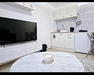 a living room with a table and a large screen tv at Apartman Vemy 1 in Trnava