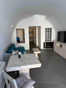 a living room with a table and a couch at Nostos Central Cave House with jacuzzi in Fira +22 photos