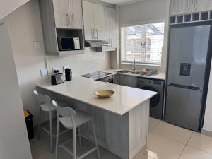 una cocina con una isla en medio de una cocina en Beautifully furnished loft apartment in central Durbanville, en Durbanville