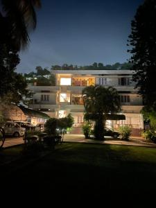 a large white building with trees in front of it at The Choudhury Manor Homestay in Guwahati