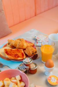 a table with a plate of breakfast food and orange juice at Kyriad Cannes - Mandelieu in Cannes