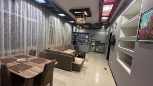 バクーにあるLarge and central apartment in the heart of Baku, close to Icheri Sheher Metro station and the Fountain Squareのダイニングテーブルとソファのあるリビングルーム