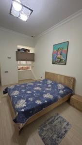 バクーにあるLarge and central apartment in the heart of Baku, close to Icheri Sheher Metro station and the Fountain Squareの青い掛け布団が敷かれたベッドのある寝室