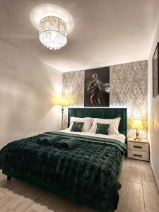 a bedroom with a large bed and a chandelier at Green Apartment - Tomis Nord in Constanţa