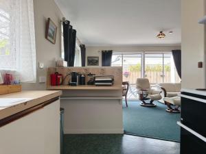 a kitchen with a counter and a living room at Kings Corner - 5min to CBD & 20min to Airport in Sandy Bay