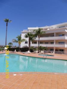 a large swimming pool in front of a building at Superbe appartement vue mer et falaises in Lagos