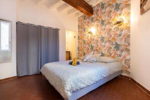 a bedroom with a bed and a floral wall at Le Nostradamus - Hypercentre - Clim - Wifi in Saint-Rémy-de-Provence