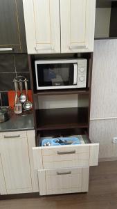 a small kitchen with a microwave and a stove at Алтын Арман in Kostanay