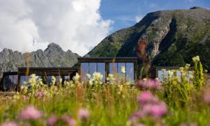 una casa di fronte a una montagna di Lofoten Arctic Lodge - sea view, jacuzzi & sauna a Lyngværet