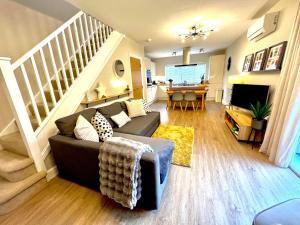 a living room with a couch and a staircase at The Duplex with Air Conditioning & Private Deck Area in Margate