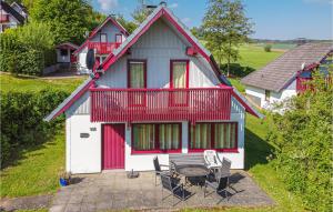 una casa rossa e bianca con tavolo e sedie di Ferienhaus 105 In Kirchheim a Kemmerode Altre 18 foto