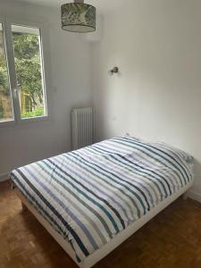 un lit dans une chambre blanche avec une fenêtre dans l'établissement Maison individuelle, à Dhuizon