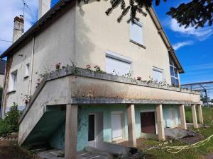 un bâtiment avec un balcon fleuri dans l'établissement Maison individuelle, à Dhuizon