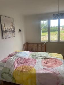 - une chambre avec un lit et une couverture colorée dans l'établissement Maison individuelle, à Dhuizon