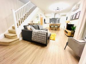 a living room with a couch and a staircase at The Duplex with Air Conditioning & Private Deck Area in Margate