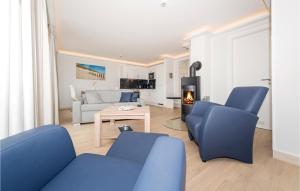 a living room with blue chairs and a fireplace at Penthouse Cloud in Binz +39 photos
