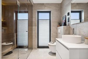 un bagno con un lavandino bianco e un water di Lofoten Arctic Lodge - sea view, jacuzzi & sauna a Lyngværet