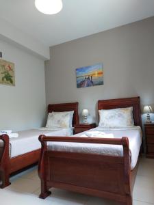 a bedroom with two beds and two lamps at Stamyra House in Liapades