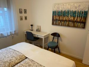 a bedroom with a bed and a desk with two chairs at Cozy City Appartement Warszawa in Warsaw