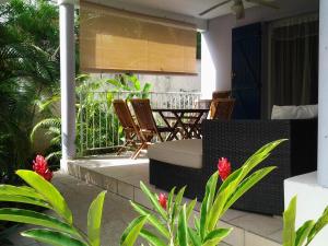 un patio con sedie e un tavolo su una casa di RESIDENCE BLEU MARINE (Appartement Bleu Océan) a Le Gosier