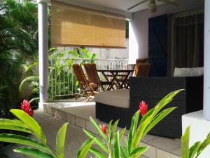 a patio with chairs and a table on a house at RESIDENCE BLEU MARINE (Appartement Bleu Océan) in Le Gosier