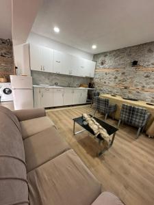 een woonkamer met een bank en een tafel bij Julia's Village Villa in Korçë