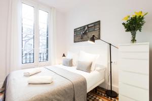 a white bedroom with a large bed with two pillows at Aspasios Urquinaona Design in Barcelona