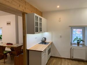 a kitchen with a sink and a table in a room at Apartmány na Vršku in Pilsen