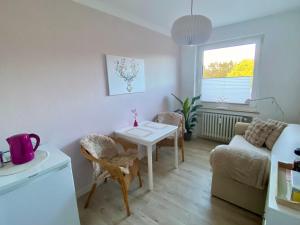 a small living room with a table and a couch at Apartment am Golfplatz in Obernkirchen