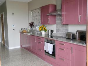 a kitchen with pink cabinets and a sink at Fife Country Escapes in Cupar