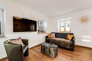 a living room with a couch and a tv at Ferienwohnung beim Kistlar - mit Biowaren in Marktoberdorf