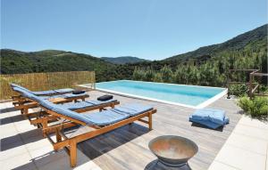 une piscine avec des chaises longues et une piscine dans l'établissement Awesome Home In St Nazaire De Ladarez, à Saint-Nazaire-de-Ladarez