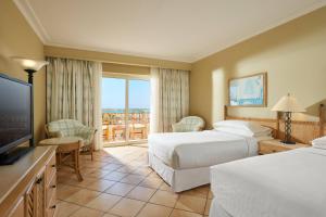a hotel room with two beds and a television at Sheraton Soma Bay Resort in Hurghada
