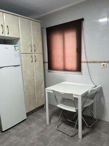 a kitchen with a white table and a refrigerator at Alojamientos La Menúa in Los Badalejos +21 photos