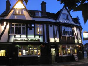 un bâtiment avec un panneau indiquant l'auberge de cygne dans l'établissement The Swan Inn Pub, à Isleworth