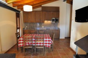 a kitchen with a table and chairs and a refrigerator at Apartaments Cal Climent in Fornols