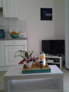 a kitchen with a table with drinks and a tv at RESIDENCE BLEU MARINE (Appartement Bleu Océan) in Le Gosier