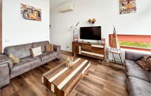 a living room with two couches and a tv at Bungalowpark Wijdland - Aak in Bunschoten