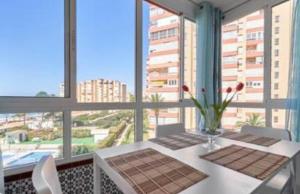 een eetkamer met een tafel en uitzicht op de stad bij Torrox Costa Mar in Torrox Costa