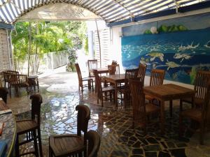 a restaurant with wooden tables and chairs and a mural at RESIDENCE BLEU MARINE (Appartement Bleu Océan) in Le Gosier