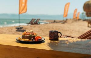 a plate of food on a table next to a beach at Sukoon Nuweibaa in Nuweiba