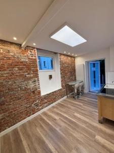 an empty room with a brick wall and a table at Apartment nah Flughafen, Messe, Arena, Dome in Düsseldorf