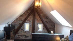 a room with a brick wall and two windows at Gesinde Loft in Schönwalde