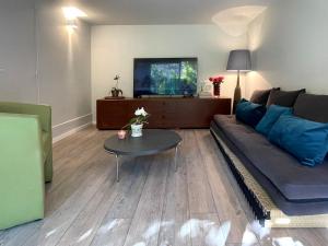 ein Wohnzimmer mit Sofa und Tisch in der Unterkunft Kiki House-belle aire près de Paris in Antony