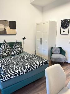 卡尔斯鲁厄Waldstadt Urban nähe KIT的一间卧室配有一张床、一把椅子和一个橱柜 更多4张照片