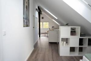 a white room with a white desk and a room with a staircase at Zentrale Ferienwohnung in Bielefeld
