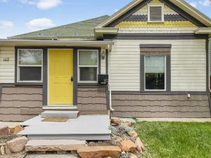 una casa con una porta gialla e un cortile di Reminiscent Downtown Cottage cottage a Grand Junction