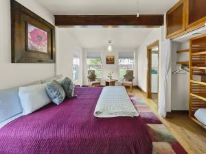 un grande letto viola in una stanza con tavolo di Reminiscent Downtown Cottage cottage a Grand Junction