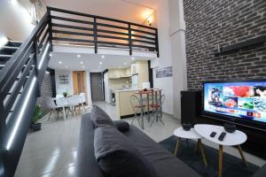 a living room with a couch and a flat screen tv at loft apartment in Athens